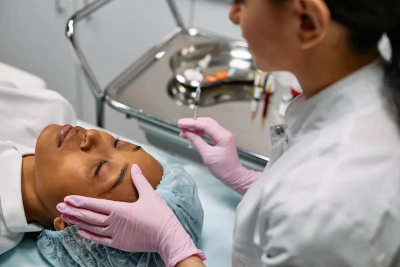 A practitioner giving a patient a facial treatment
