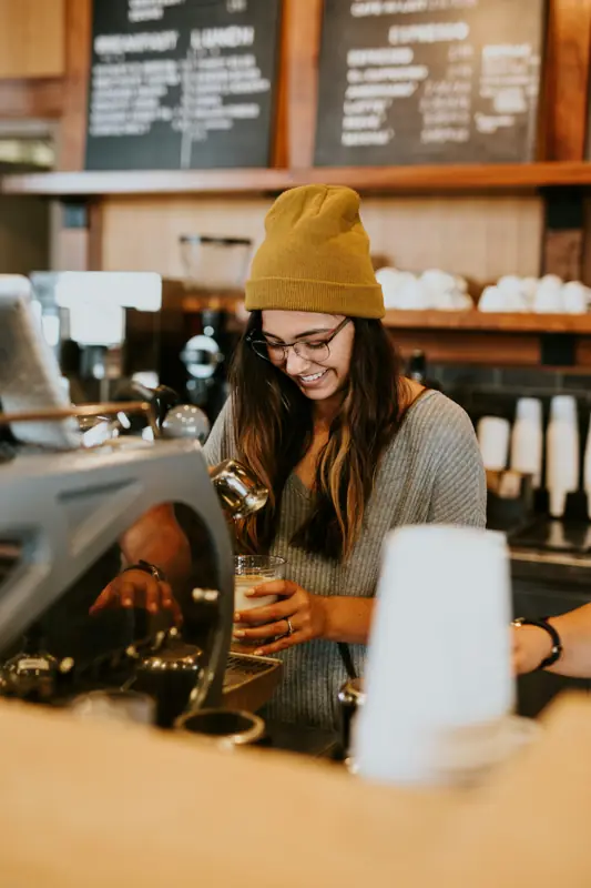 A barista smiling at the espresso machine