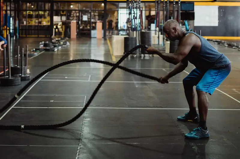 A man training with battle ropes in a gym
