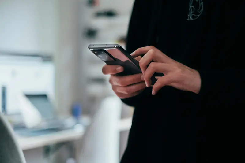 A phone in a shop owner's hand