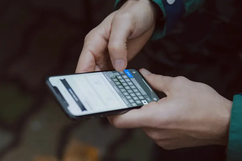 Hands typing a message on a phone